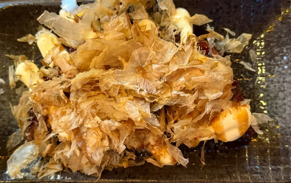 Okonomiyaki topped with sauce and mayonnaise