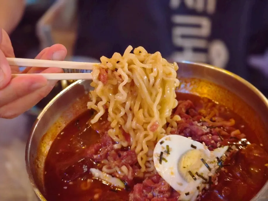 Close-up of fire chicken cold noodles topped generously with yukhoe