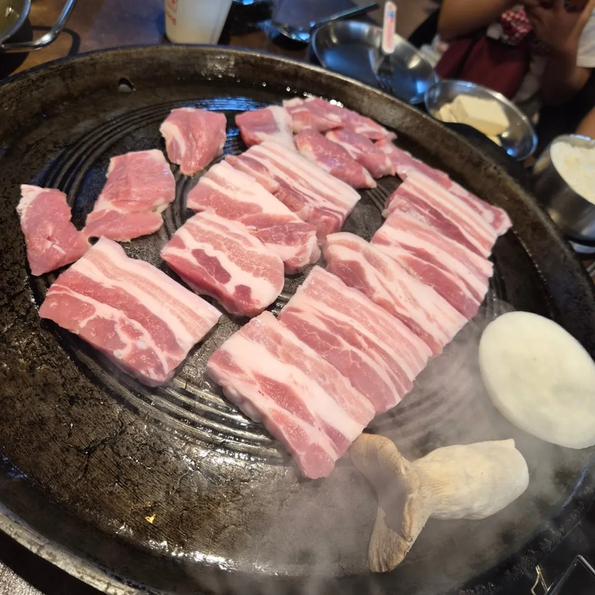 Ogyeopsal and kimchi on the cauldron lid