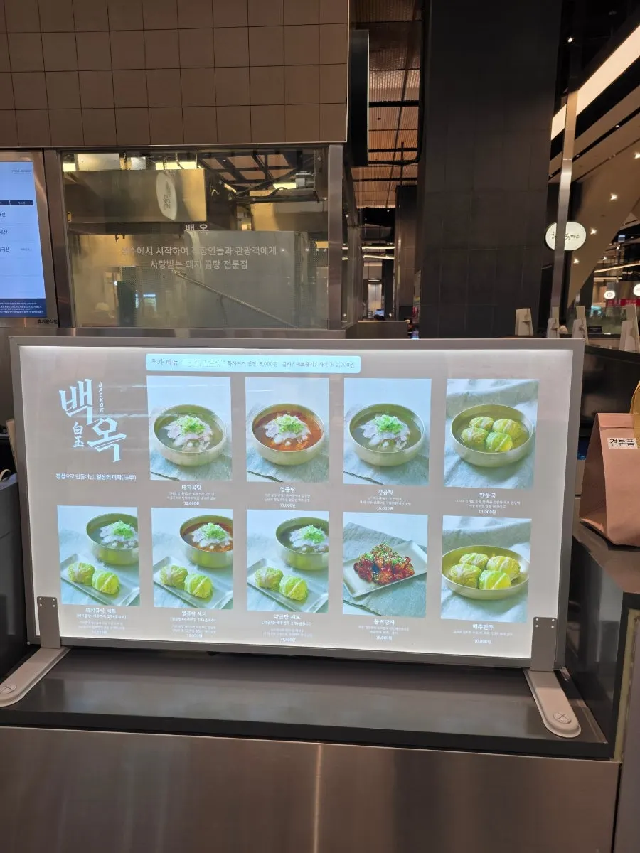 백옥 로고가 있는 핑크색 포장 가방