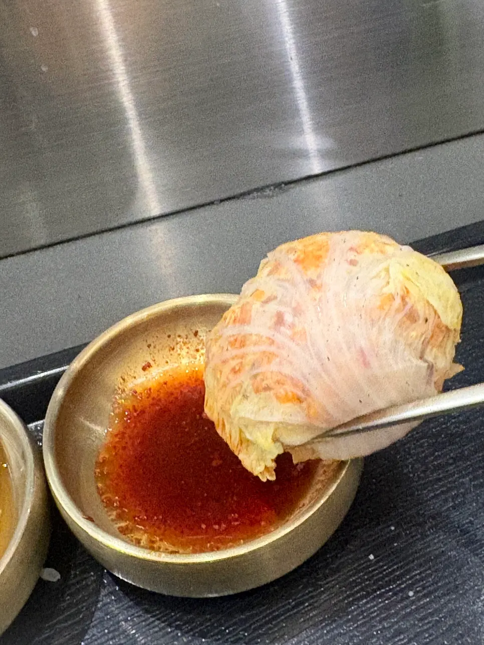 A bite of kimchi dumpling eaten with gomtang