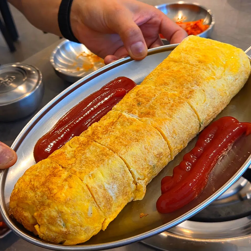 Eating egg roll together with kimchi jjigae