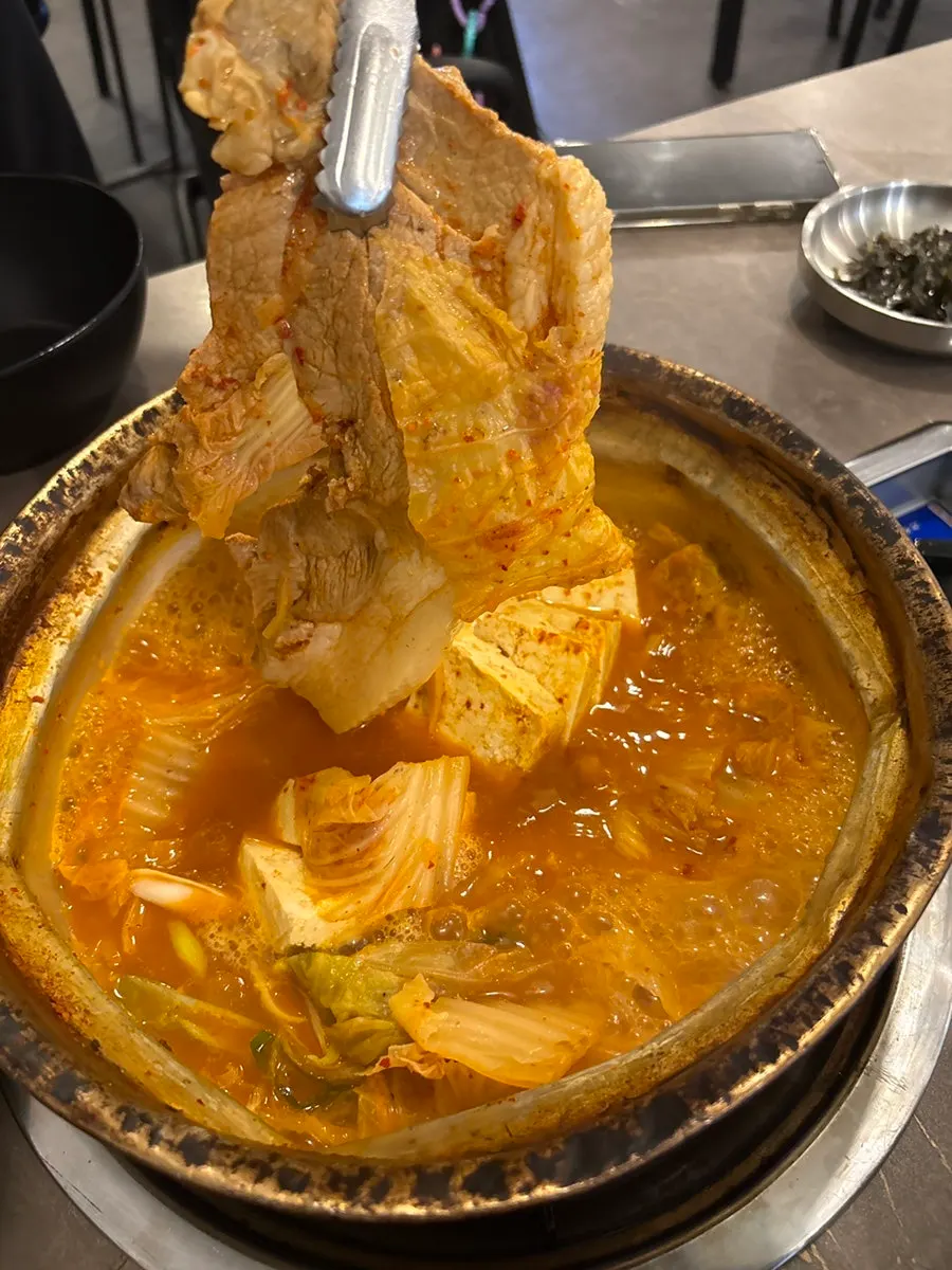 젓가락으로 집어 든 계란말이 한 조각