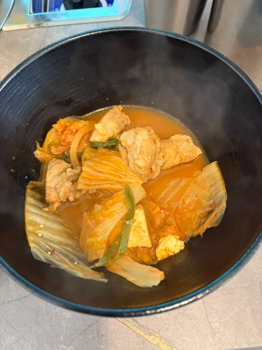 끓고 있는 김치찌개 국물과 두툼한 고기