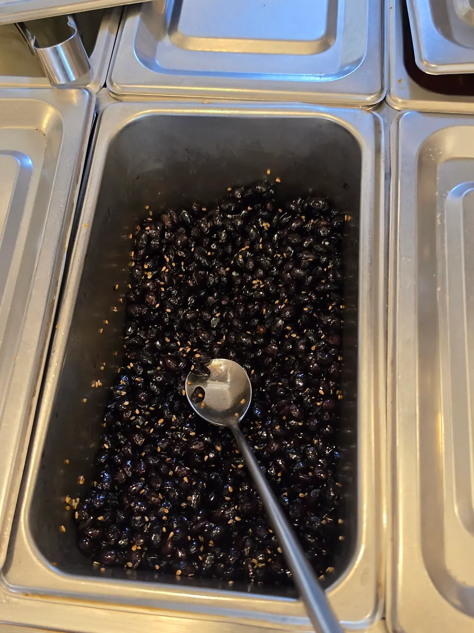 Self-serve bar with dried radish strips, seasoned black beans, and ssamjang