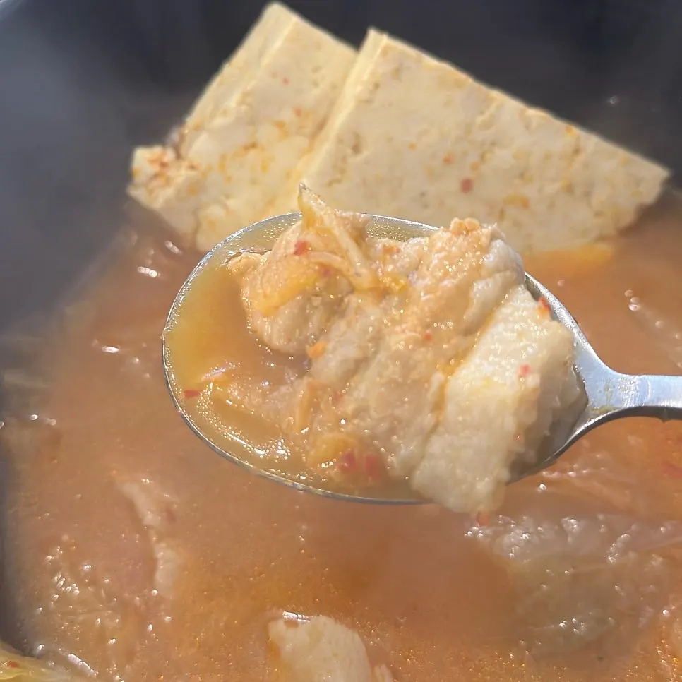 Chunks of meat from the kimchi jjigae cut with scissors