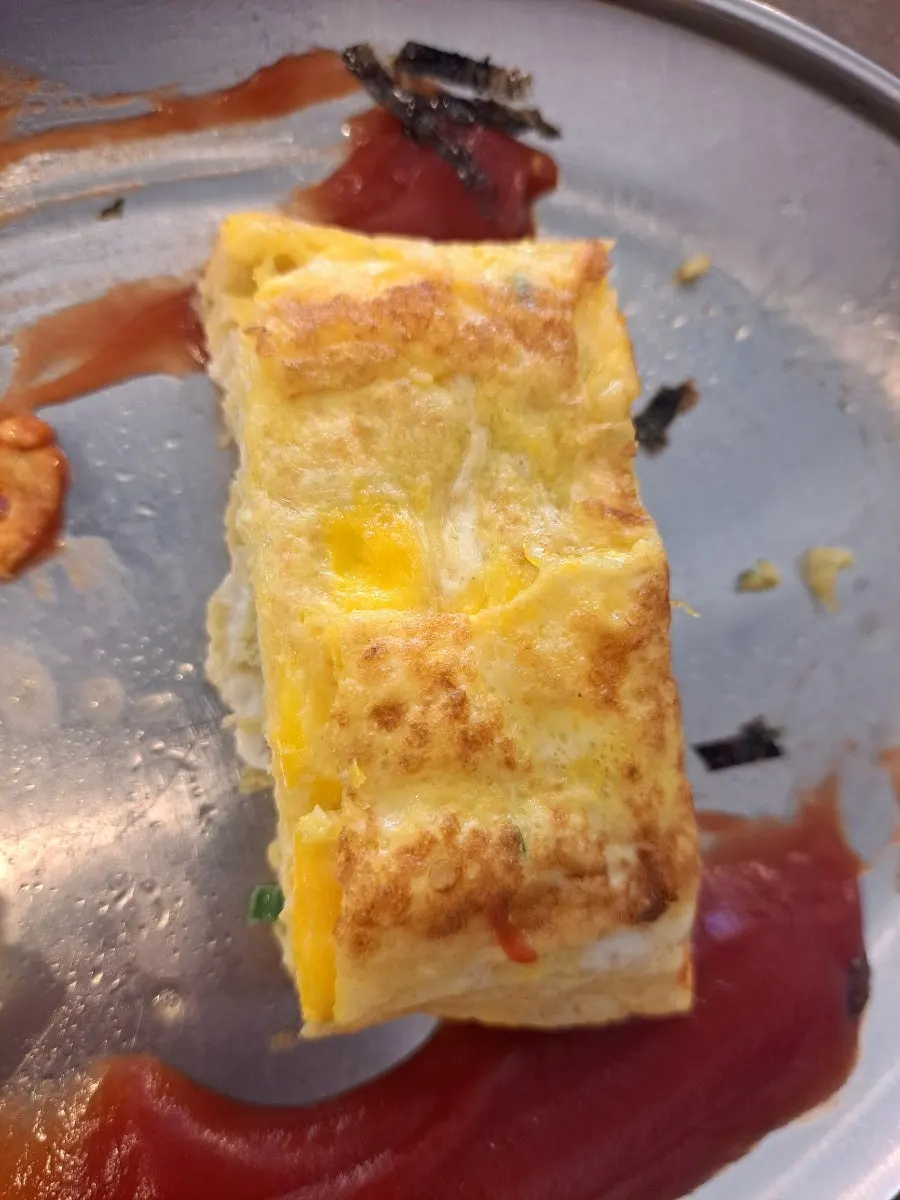 Cross-section of the large egg roll drizzled with ketchup