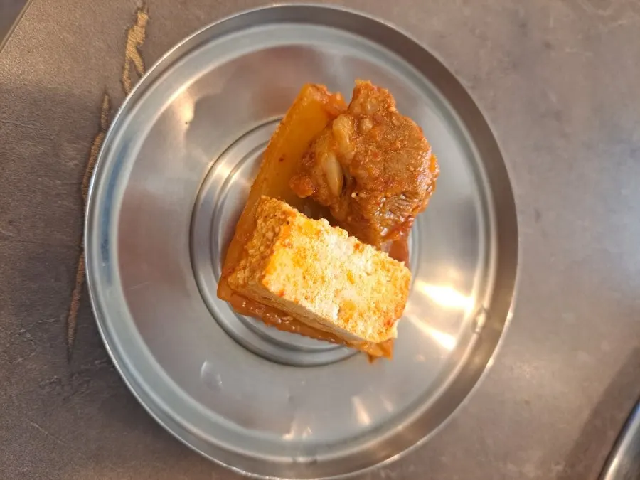 A piece of kimchi jjim placed on top of rice