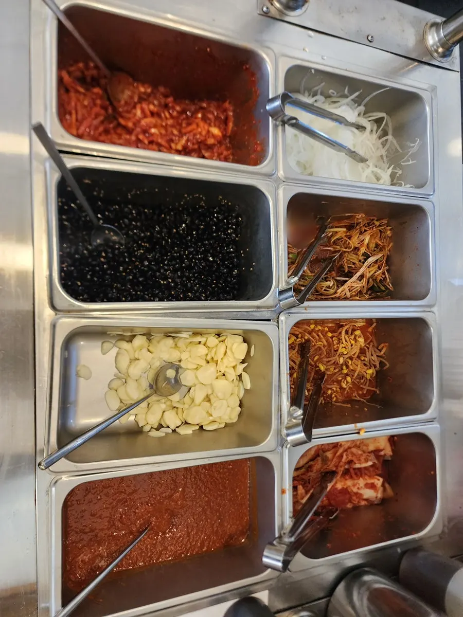 Self-serve bar with pickled onion, seasoned chives, and bean sprouts