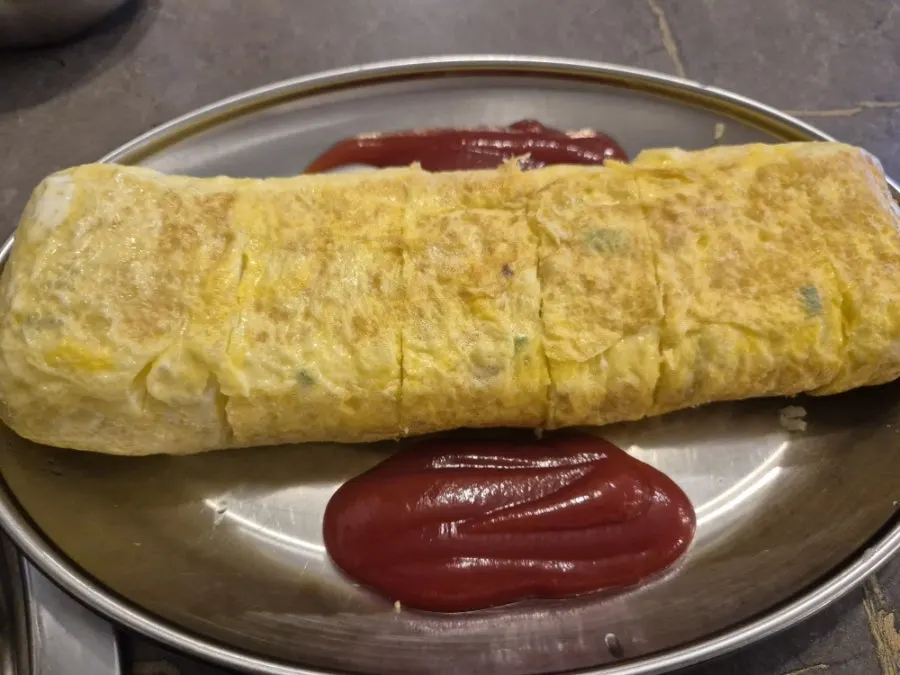 Egg roll served alongside bowls of rice as part of the set