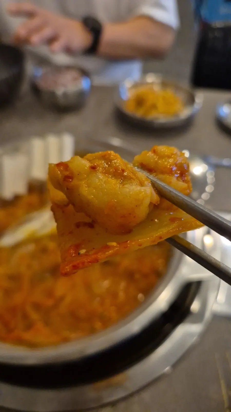 Table with steaming kimchi jjim and egg roll