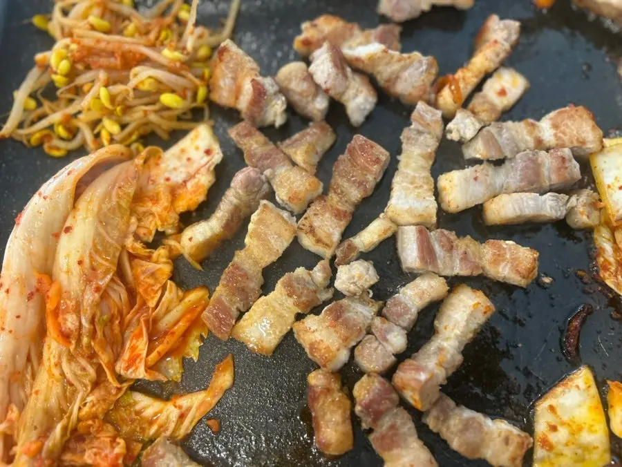 불판 위에서 익어가는 삼겹살과 김치