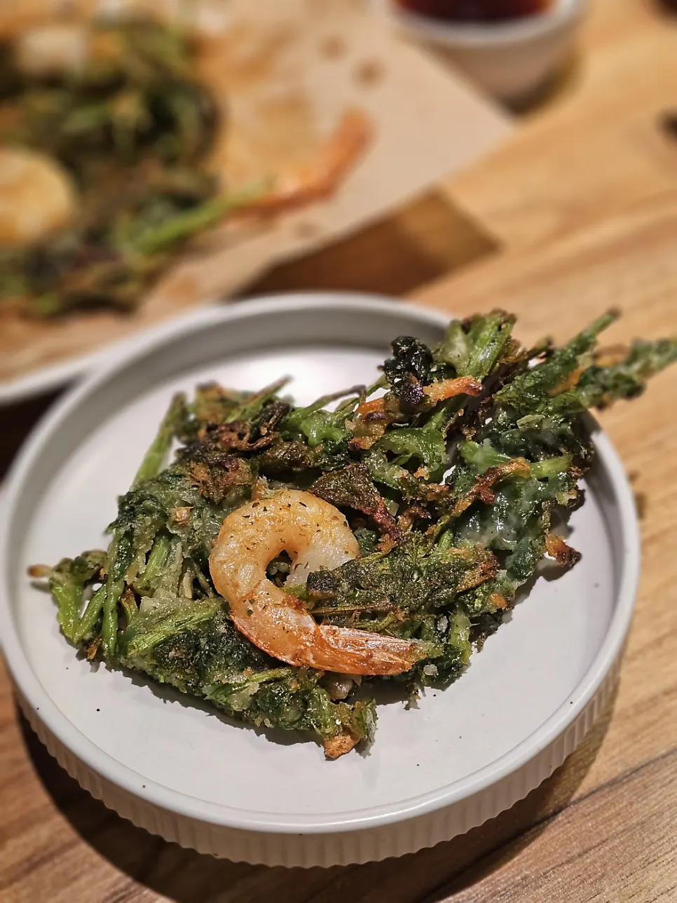 A piece of the minari pancake topped with shrimp