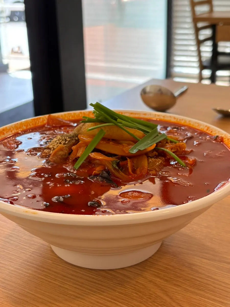 Close-up of the jjamppong broth full of cockles