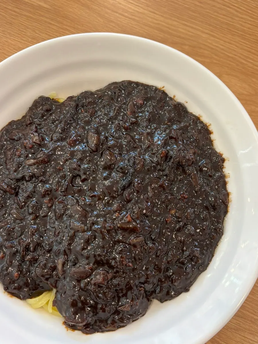 A chopstick full of cockles over the noodles