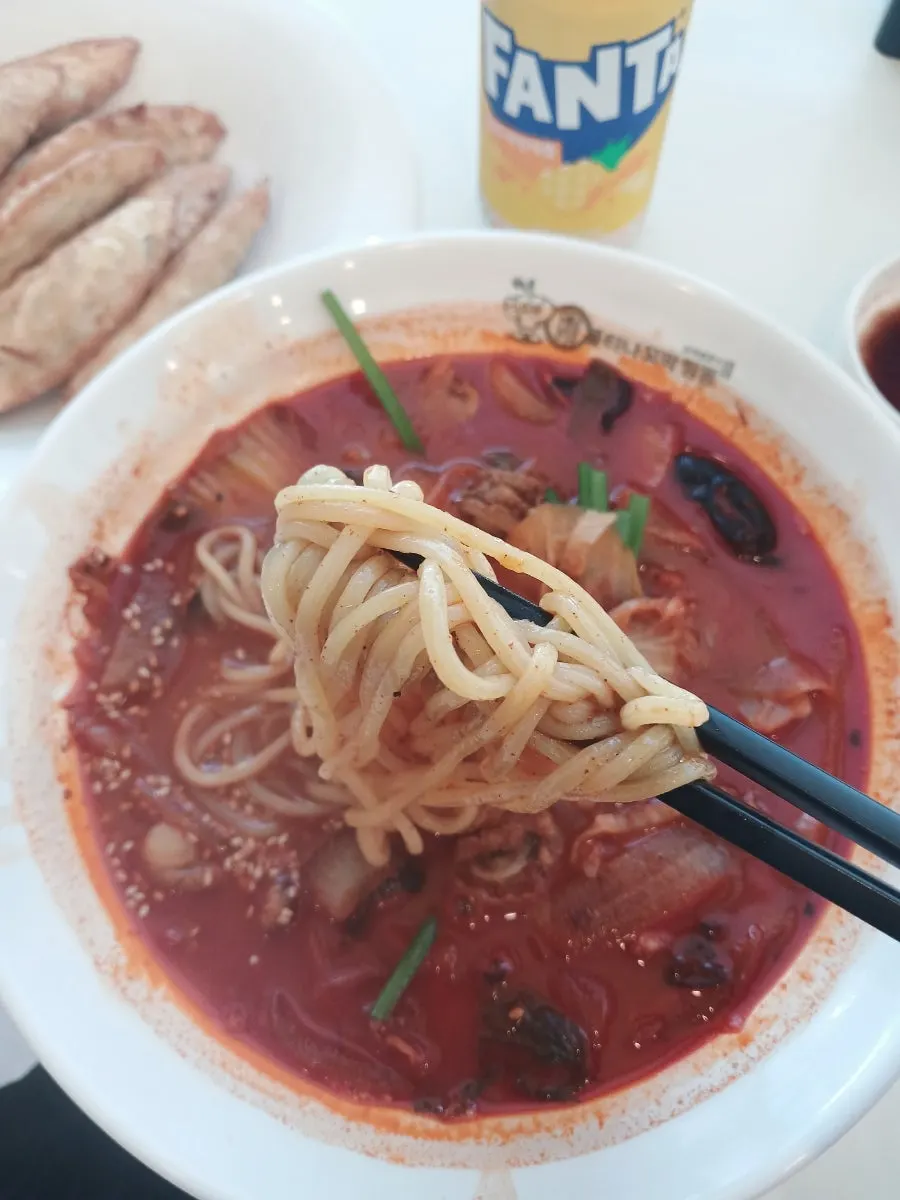 Lifting up noodles and broth from a bowl of jjamppong