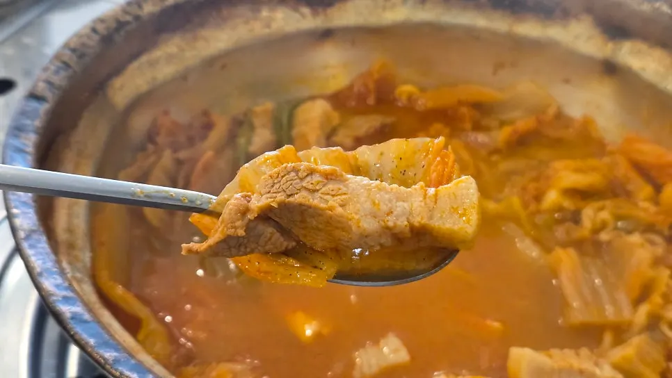 A piece of pork belly topped with well-fermented kimchi