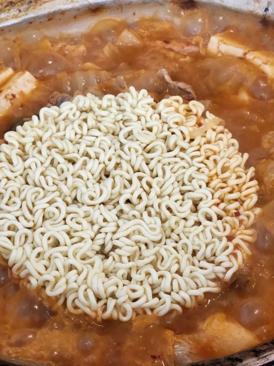 Ramyeon noodles added into the kimchi jjigae