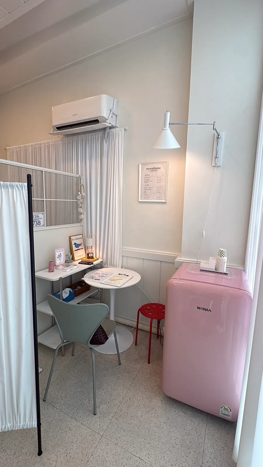 Space inside the shop with pink props and a small fridge