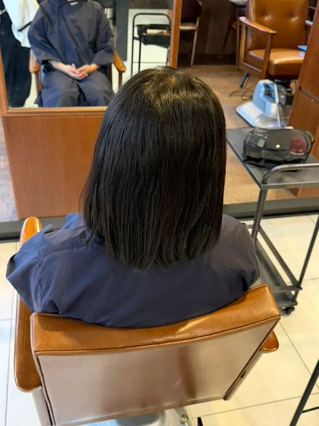 Curly bob puffing out to the side before the treatment