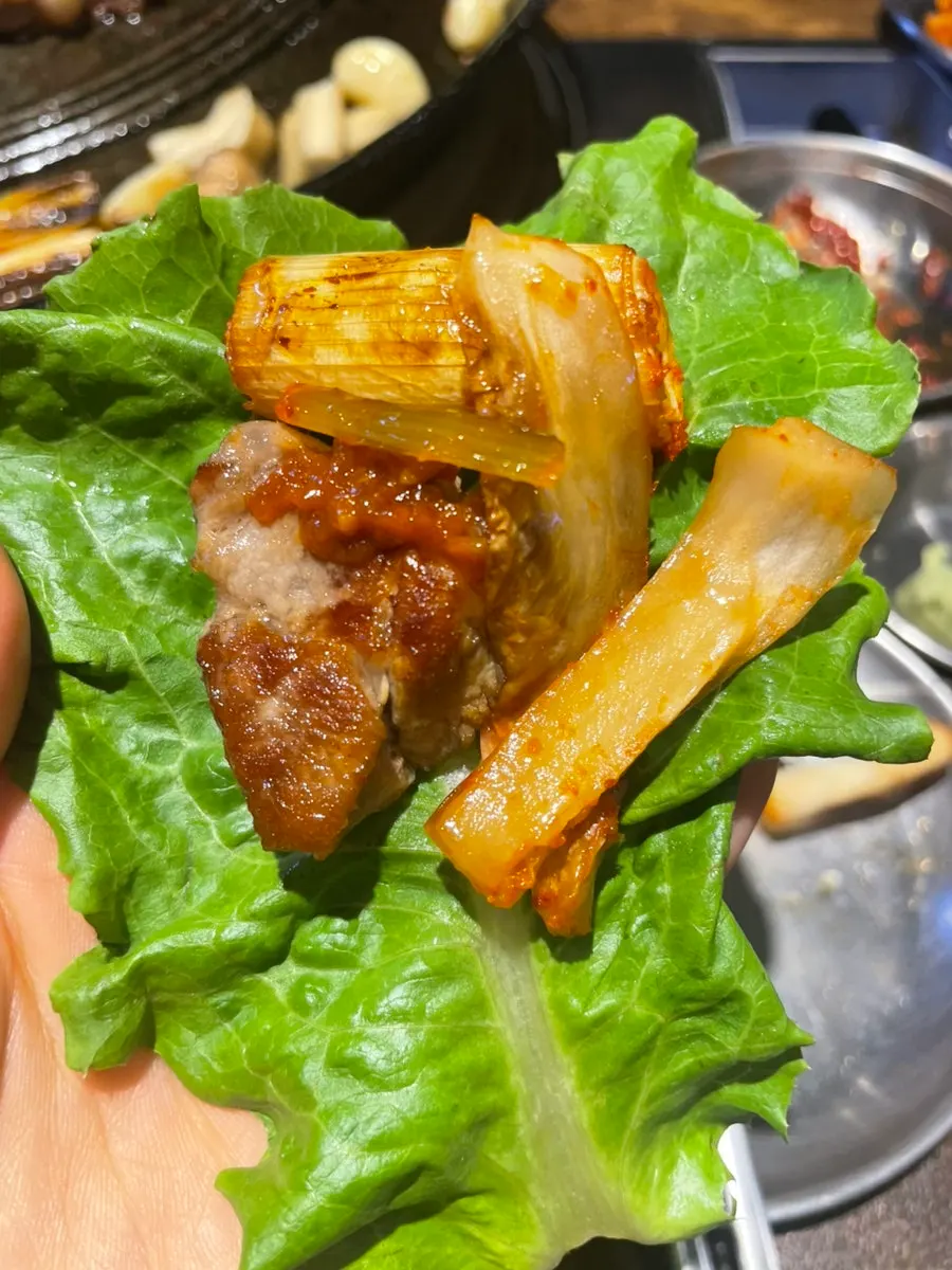 수제 밑반찬에 올린 고기 한 점