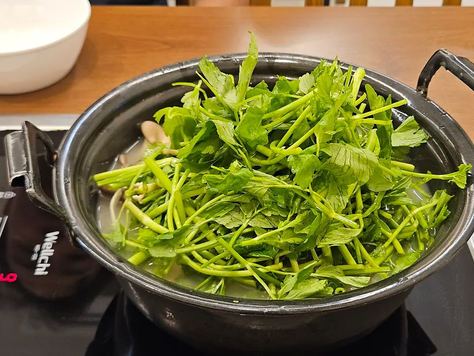 Clear mushroom kalguksu broth with mushrooms and vegetables laid out
