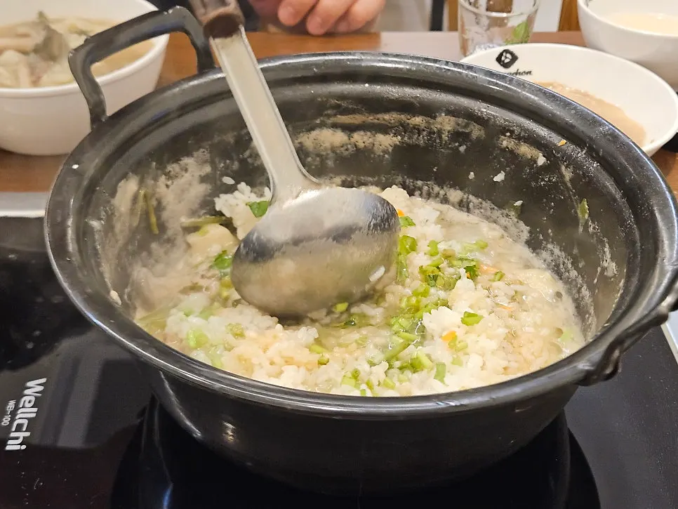 Scooping out kalguksu noodles and sujebi to eat