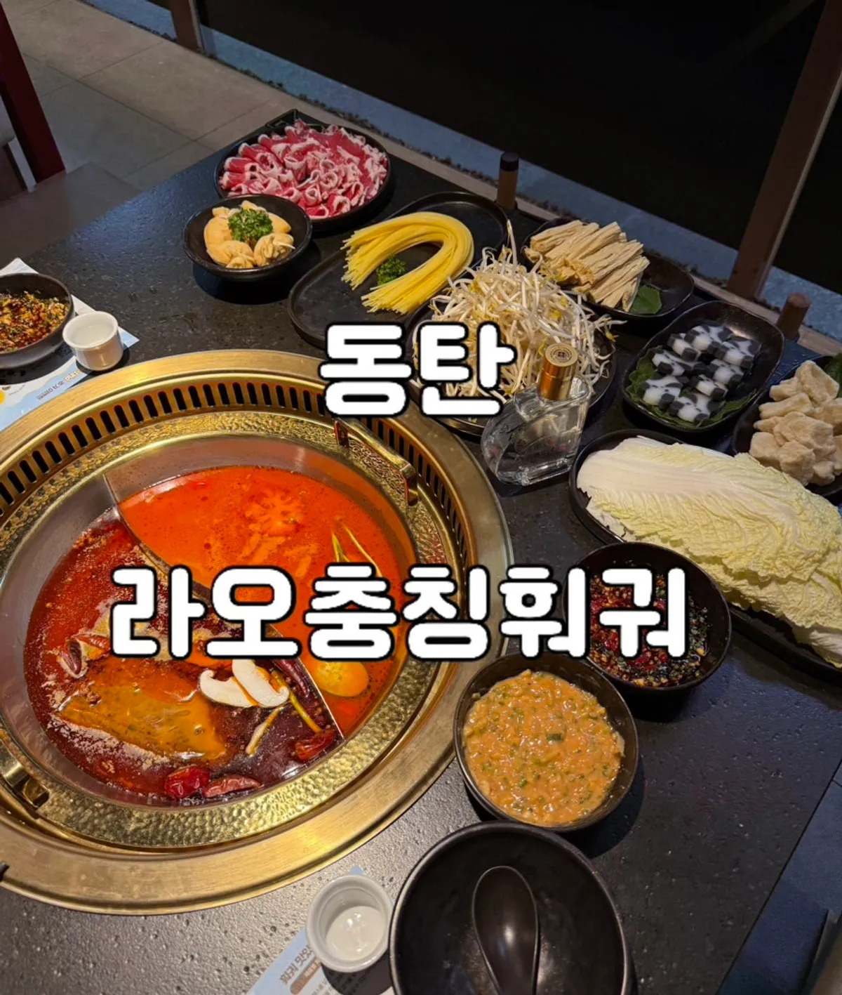 Half-and-half hotpot table setting with Chengdu red broth and tomato broth at Lao Chongqing Hotpot