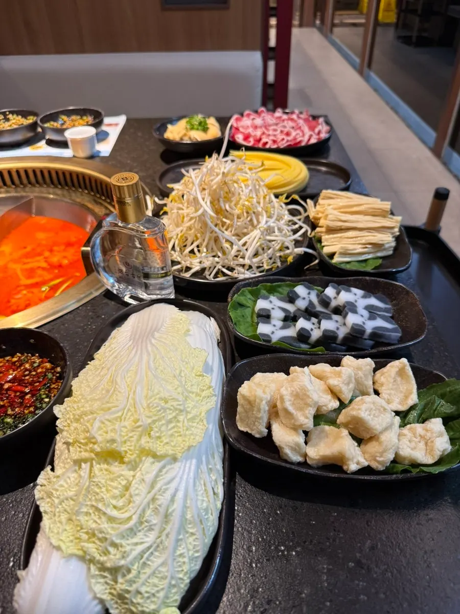 Plate of hotpot vegetables including bean sprouts and napa cabbage