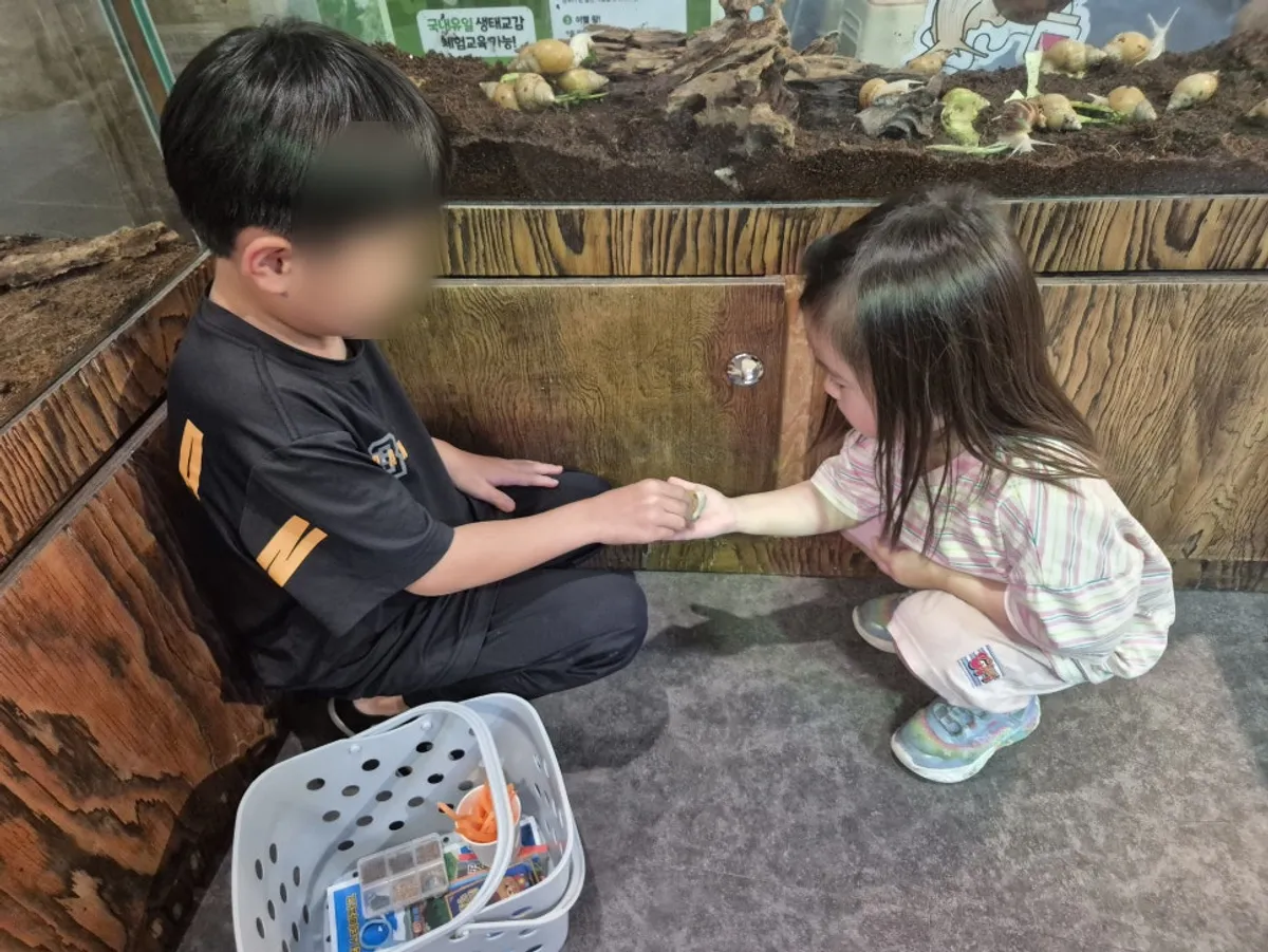 먹이를 들고 동물원 내부로 들어가는 아이들