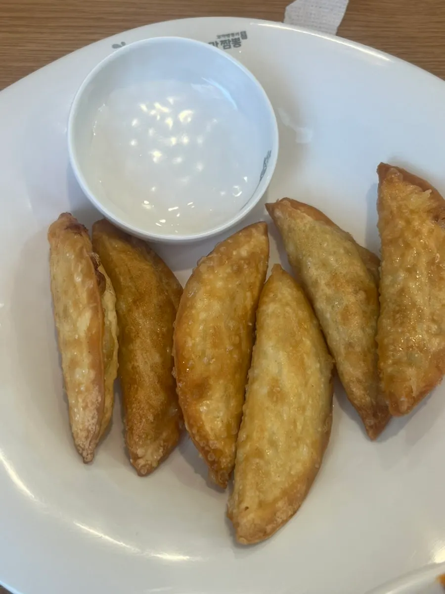 A plate of fried dumplings served alongside jjamppong