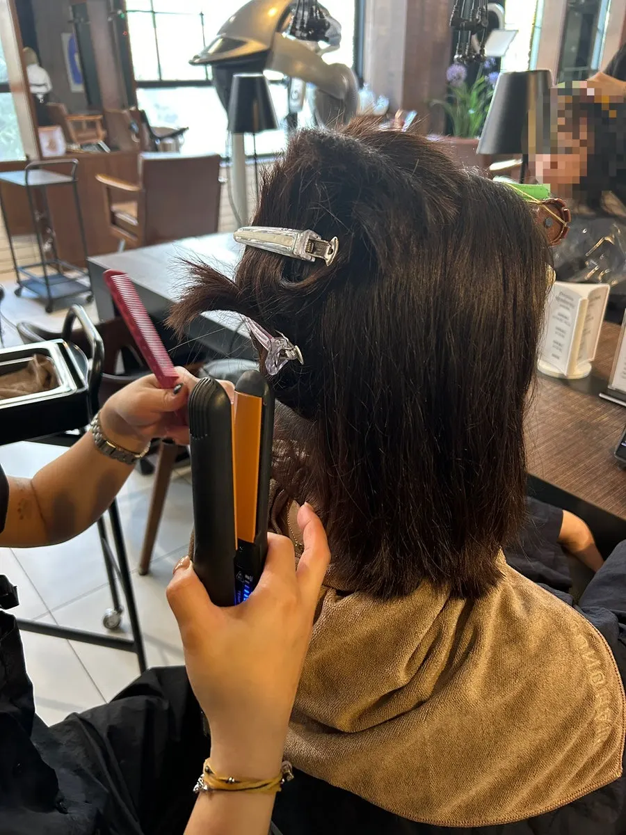 Straightening iron smoothing the hair
