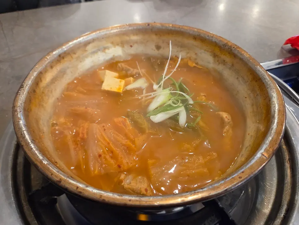 Kimchi jjigae bubbling in an aluminum pot