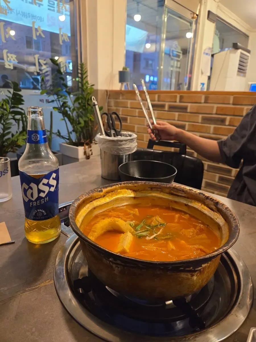 A large whole chunk of pork inside the kimchi jjigae