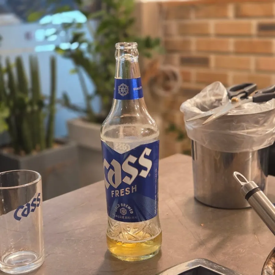 A glass of beer poured alongside the kimchi jjigae