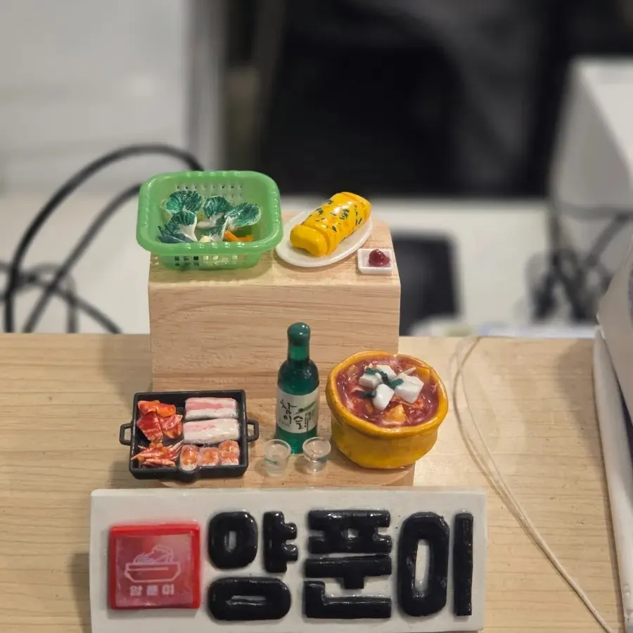An emptied beer bottle beside the remaining kimchi jjigae