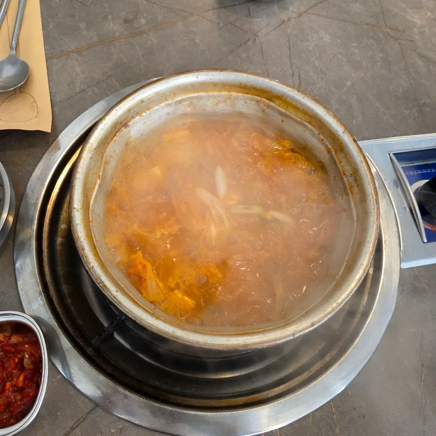 Table with kimchi jjigae and duruchigi eaten in turns