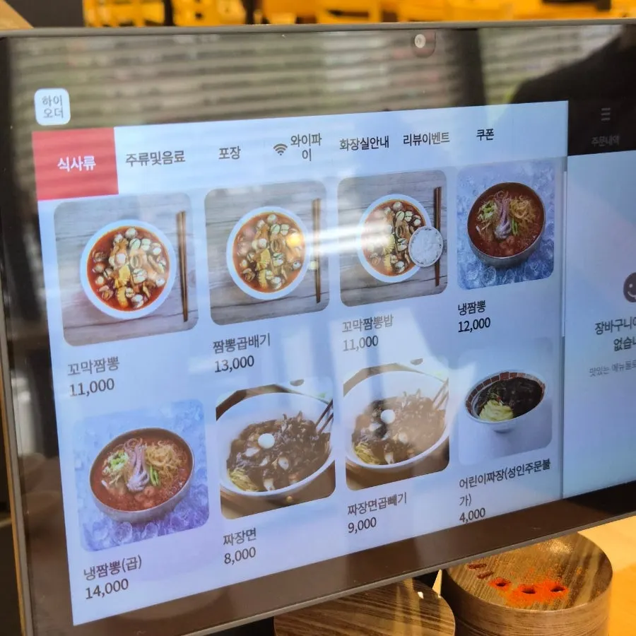 Menu board listing cockle jjamppong and jajangmyeon