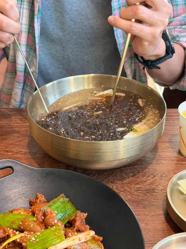 Spicy gochujang pork belly eaten with naengmyeon