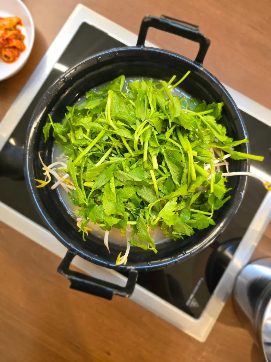 Table setting with two servings of clear mushroom kalguksu and added shabu beef