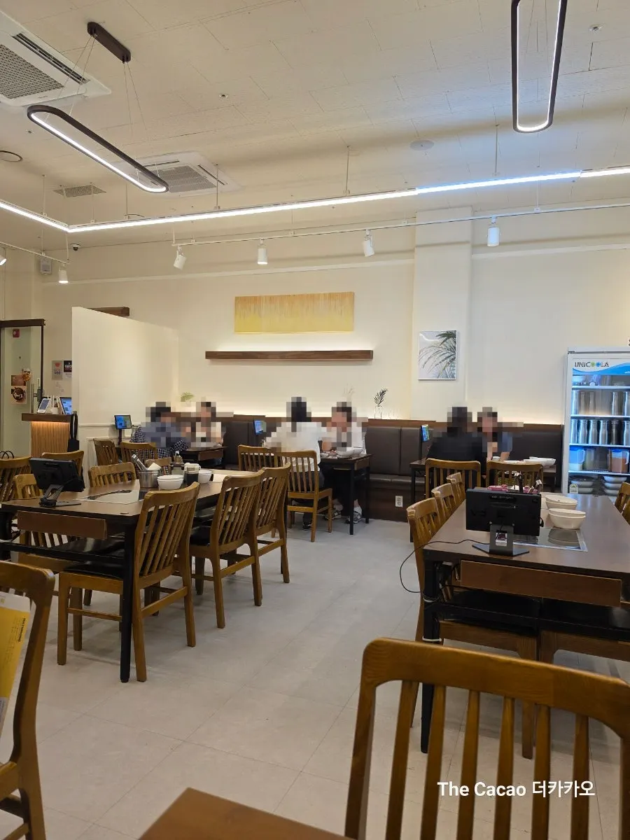Interior of Deungchon Shabu Kalguksu in white and wood tones