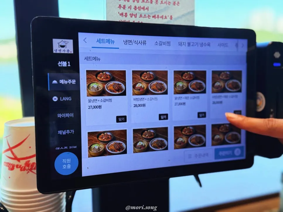 Menu board listing bibim-naengmyeon, mul-naengmyeon, and meat dishes