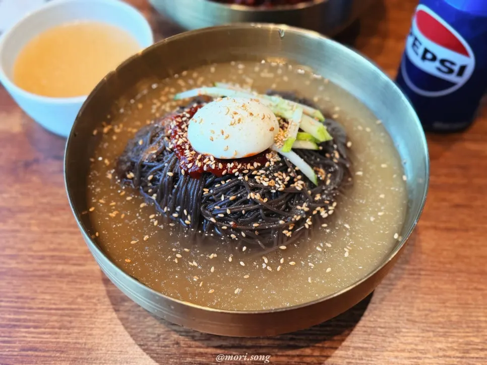 A bowl of bibim-naengmyeon with the noodles mixed in