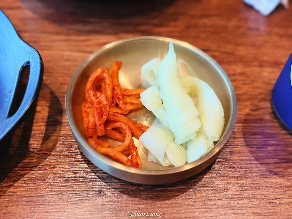 Side dishes piled on top of the naengmyeon noodles