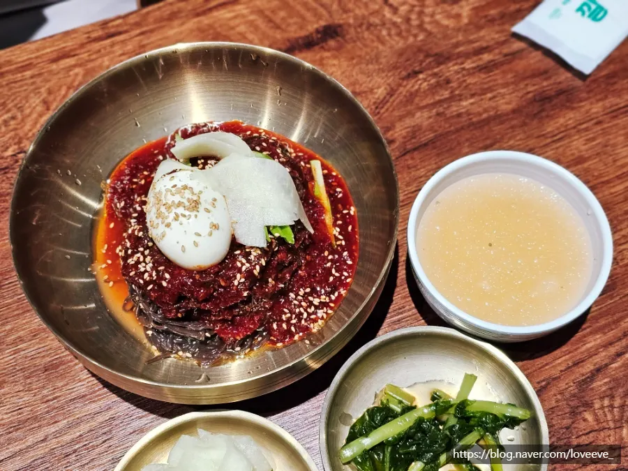 Two bowls of mul naengmyeon and bibim naengmyeon
