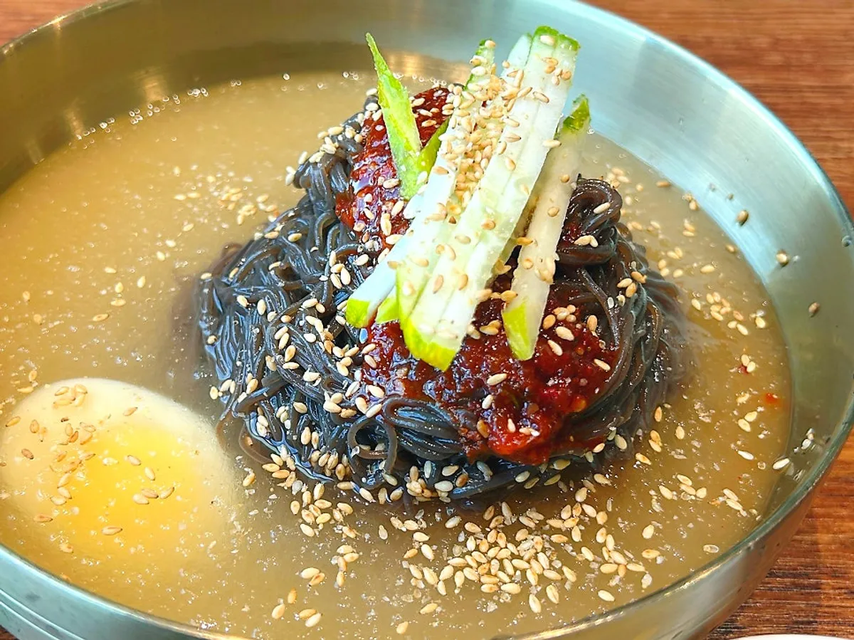 Table spread of mul-naengmyeon and spicy bibim kudzu naengmyeon