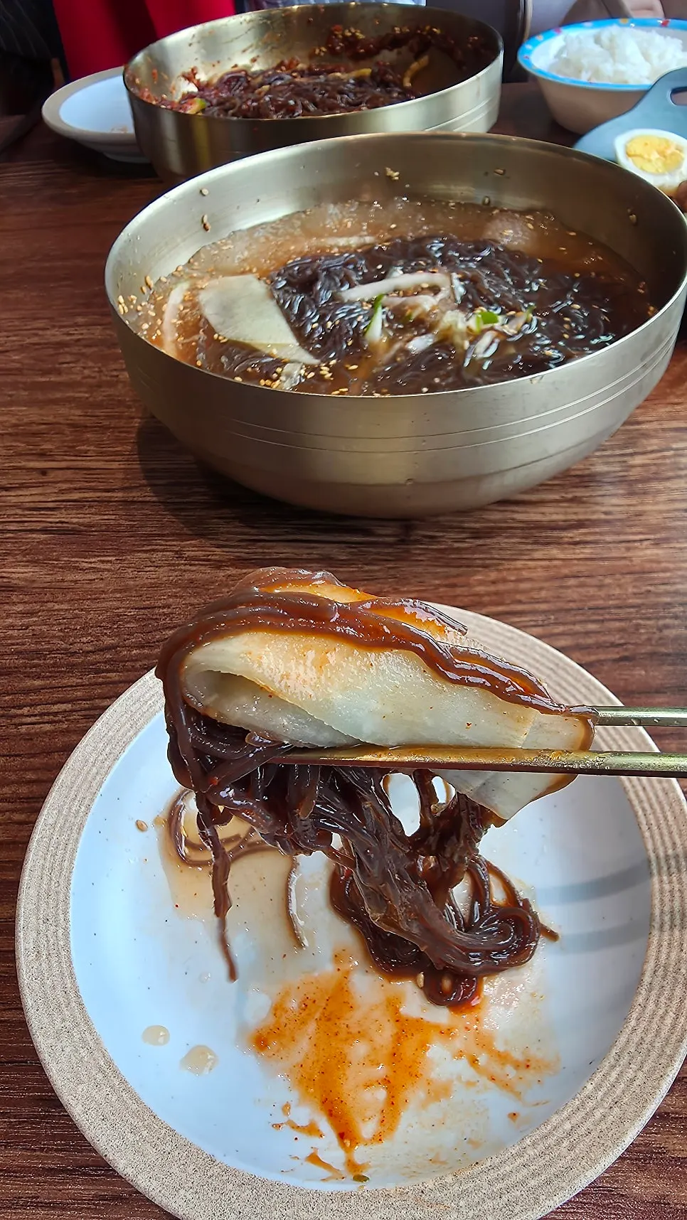 A bowl of naengmyeon enjoyed with the lake park view