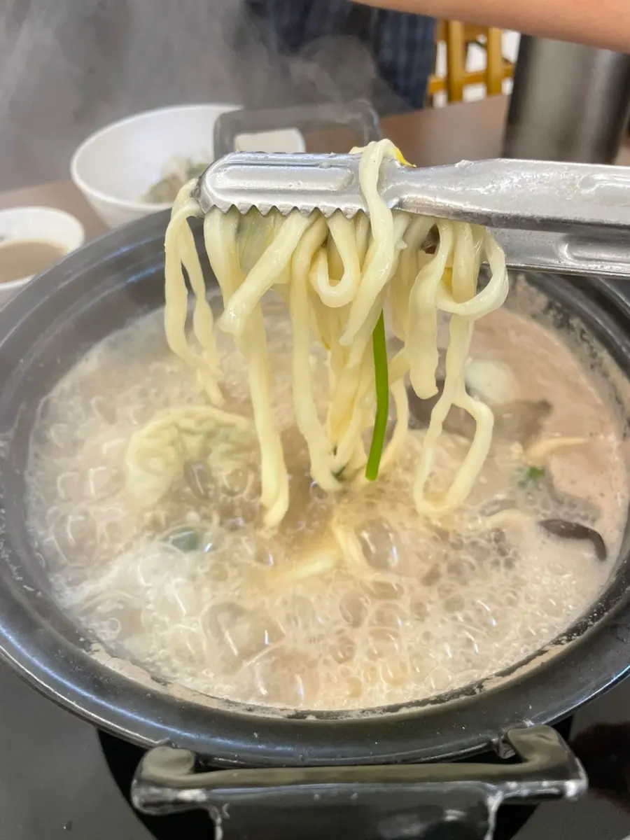 Kalguksu noodles and dumplings added into the broth