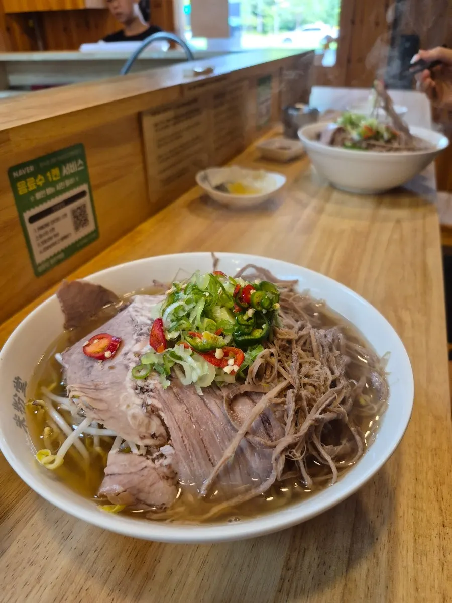 Two bowls of pho and a side order