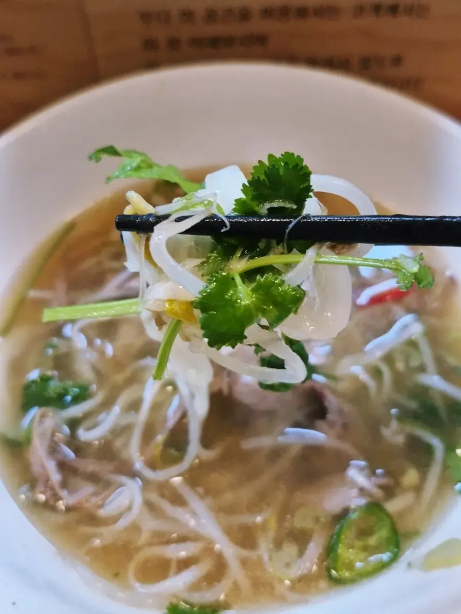 Pho meal with hot sauce